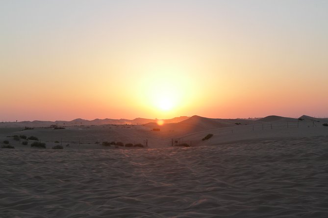 Abu Dhabi Desert Safari with BBQ Dinner & Shows - Sunset over Abu Dhabi’s red sand